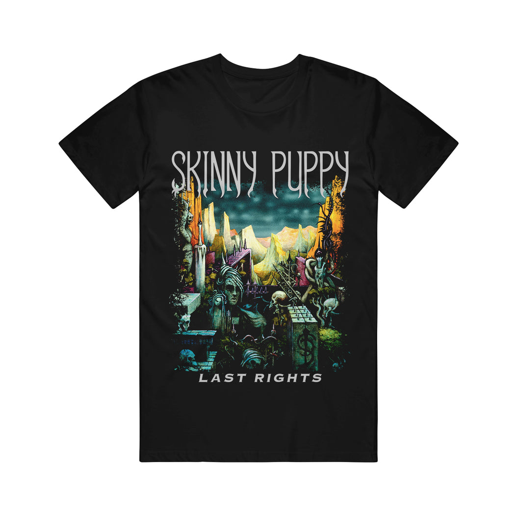 Black tshirt on a white background. The words skinny puppy are across the chest in white. At the bottom of the shirt in white says the words last rights. In the center of the shirt, in between the words is a design of a city or ruins- there is a dark blue sky, pointy rocky mountains, Skeletons, statues, spiked objects, and vines. The bottom of the image shows the black SP logo.